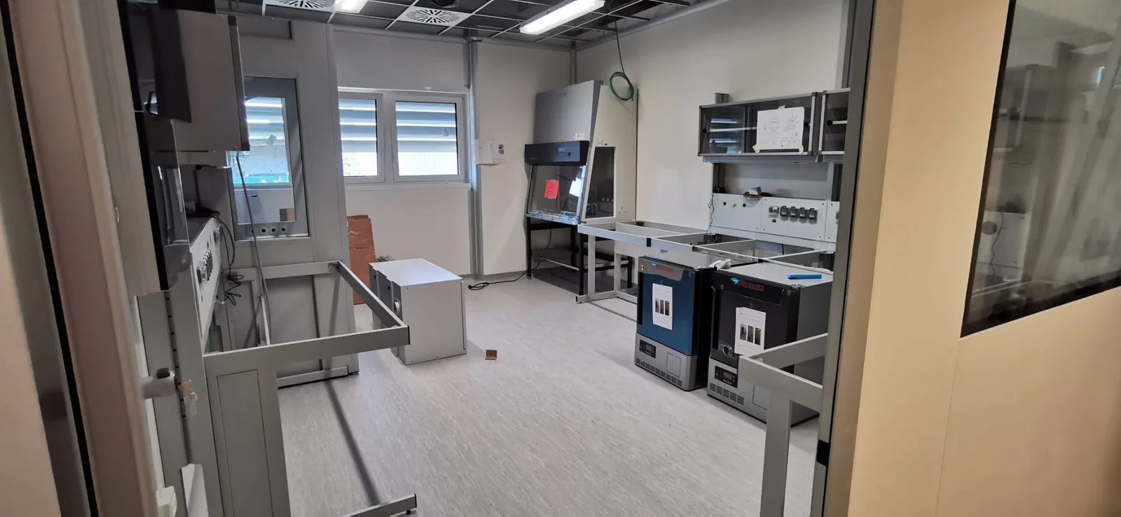 Ambiente di laboratorio con banchi, apparecchiature e distribuzione impiantistica